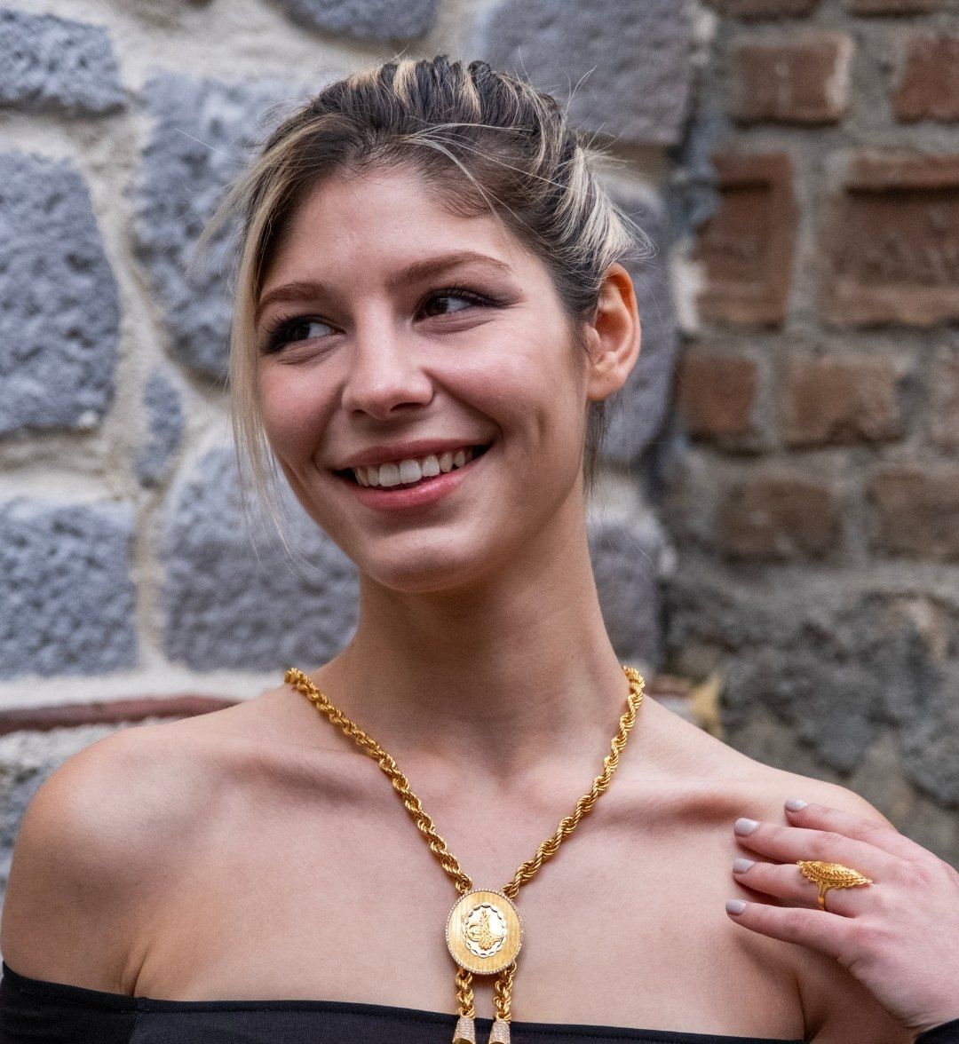 Reşat coin necklace with a round tughra medallion and tassels on a rope chain, worn by a model