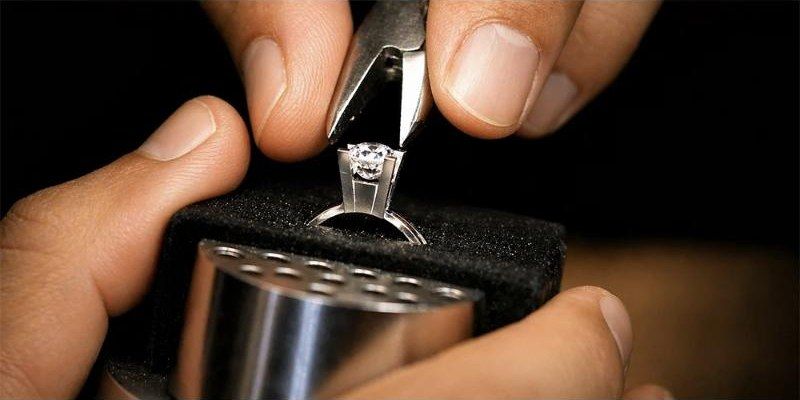 Craftsman's hands setting a diamond into a ring